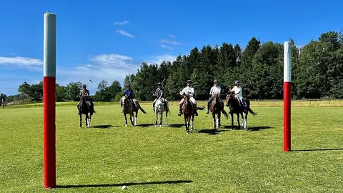 Ryttere mellom målstolpene på polobanen